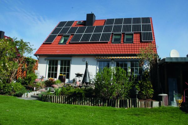 Ein Haus mit Photovoltaik-Modulen auf dem Dach.