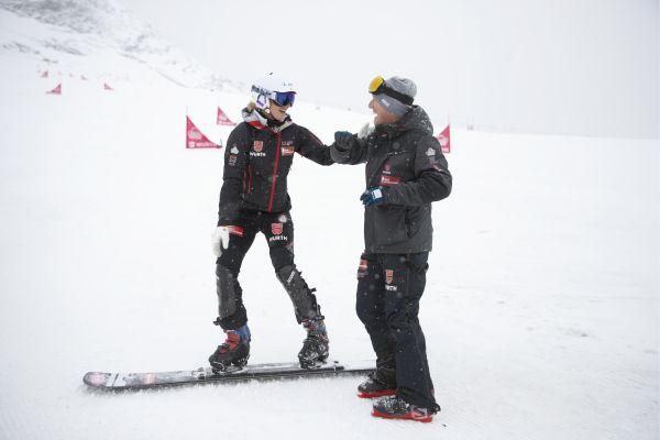 Das Bild zeigt zwei Snowboardfahrer im Schnee.