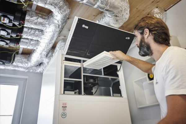 Ein Mann wechselt den Luftfilter einer Haustechnikzentrale.
