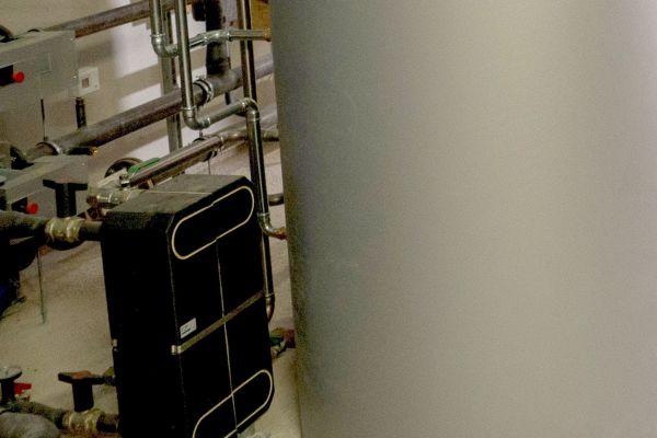 Wärmeübertrager und Warmwasserspeicher in einem Heiztechnikraum.