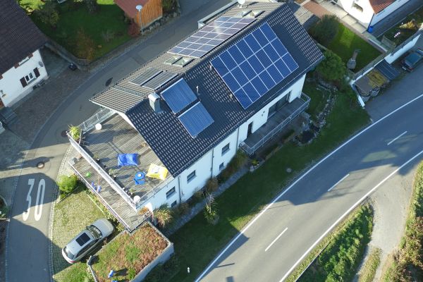 Ein Haus mit einer Solarthermieanlage auf dem Dach von oben.