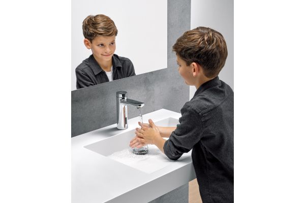 Das Bild zeigt einen Jungen, der sich die Hände wäscht.