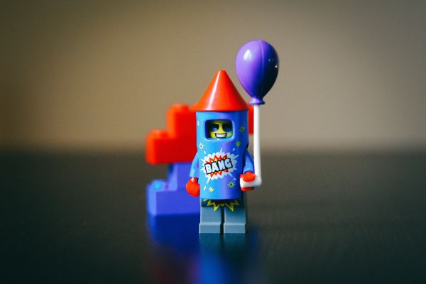 Ein Lego-Männchen in einer Rakete mit einem Luftballon in der Hand.