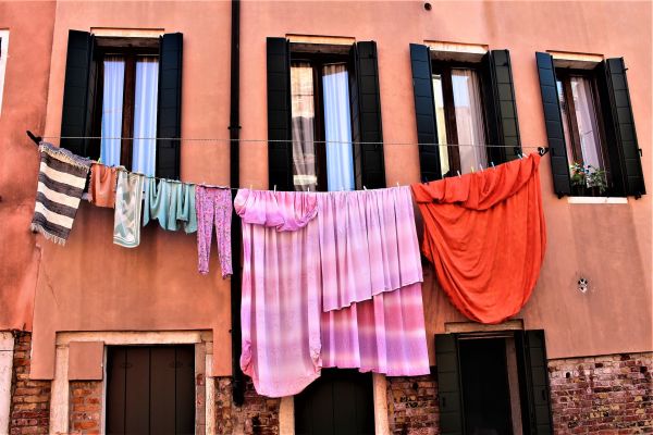 Wäscheleine mit Kleidung vor Fenstern.