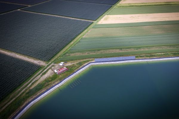 Wasserreservoir mit den dahinterliegenden Feldern.