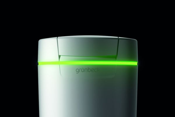 Das Bild zeigt die weiße Enthärtungsanlage „softliQ:SC23“ von Grünbeck mit grün leuchtendem LED-Ring vor einem schwarzen Hintergrund.