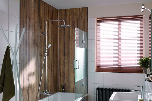 Das Bild zeigt einen Badausschnitt mit einer Badewannendusche, die mit dem Wandverkleidungssystem 