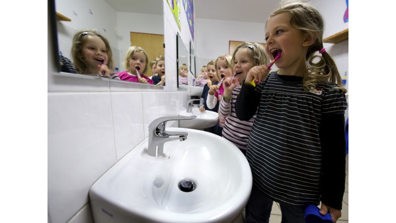 Das Bild zeigt Kinder beim Zähneputzen.