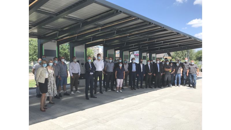 Eine Gruppe Menschen steht an der E-Tankstelle von Schneider Electric in Lahr.