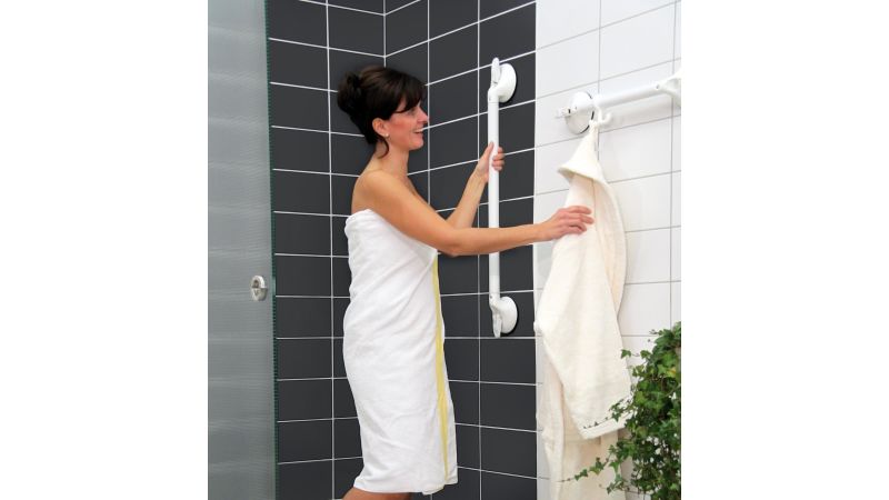 Eine Frau hält sich an einem Haltegriff in der Dusche fest.