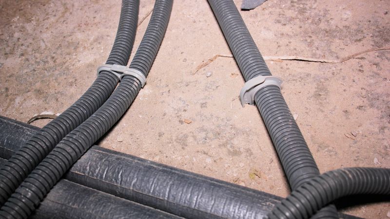 Das Bild zeigt, wie eine Einzelleitung und eine parallel verlegte Leitung mithilfe eines Stecksystem auf dem Boden fixiert sind.