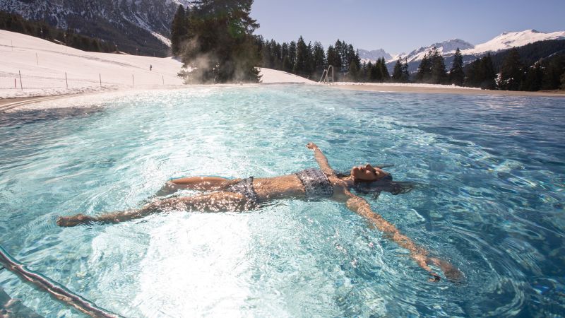 Eine Frau schwimmt auf dem Rücken in einem Swimmingpool.
