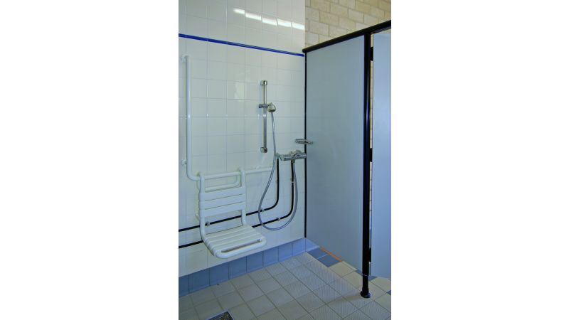 Ein barrierefreier Sanitärraum in einem Schwimmbad inklusive Dusche.