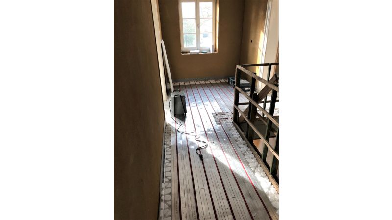 Foto: Verlegung Trockenbau-Fußbodenheizungssystem „ClimaComfort“ im Altbau.