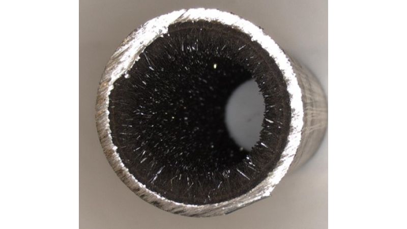 Foto: C-Stahlrohr mit einem kristallinen Belag aus Magnetit und Kalziumkarbonat (Aragonit).