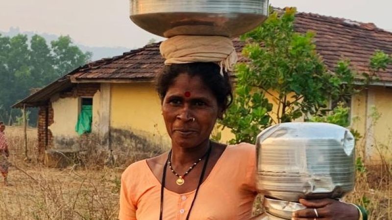 Das Bild zeigt eine indische Frau, die Wasser transportiert.