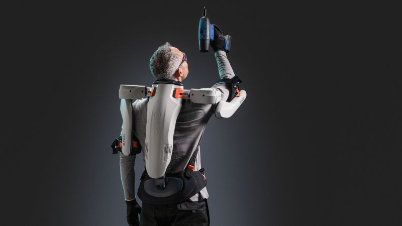 Bild zeigt einen Handwerker beim Arbeiten über Kopf: Dieses akkubetriebene Schulter-Exoskelett unterstützt mit bis zu 5 kg Kraft pro Arm – gerade auch bei Arbeiten über Kopf. 