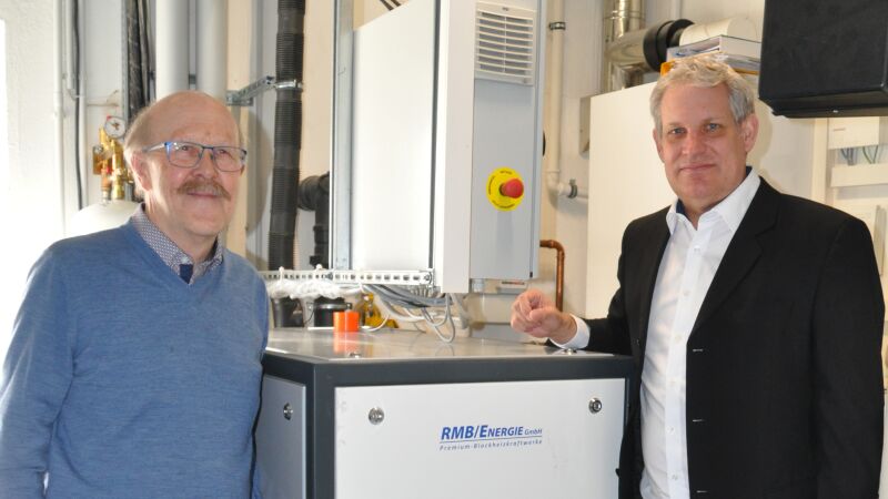 Erwin Rössle und Roy Block (re.), RMB/Energie-Vertrieb Deutschland Süd und Österreich, am BHKW „neoTower 20.0“. Dieses stellt die Grundlast an Wärme und Strom in der „Kletterei“ bereit.
