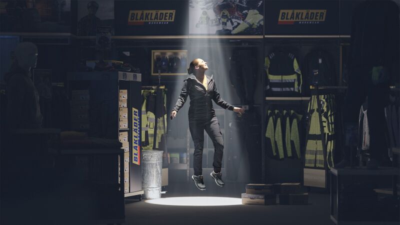 Das Bild zeigt eine Frau, die sich in einem Blåkläder-Store erhebt.