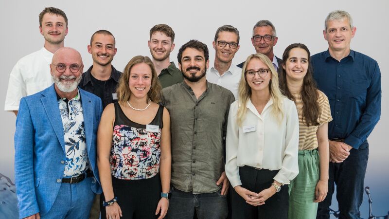 Das Bild zeigt Constantin Wragge (Preisträger), Michael Mall (Stiftungsvorstandsvorsitzender der Roland Mall-Familienstiftung und Mitglied der Jury), Felix Görrissen, Marisa Poggioli, Sandro Hunziker, Dr.-Ing. Carlo Morandi (alle Preisträger/-innen), Prof. Dr.-Ing. Ulrich Dittmer (RPTU Kaiserslautern-Landau und Jury-Mitglied), Laura-Celine Warner (Preisträgerin), Dr. Guido Schmuck (Mitglied des Stiftungsrats und der Jury), Anna Breuer (Preisträgerin) und Prof. Dr.-Ing. Heiko Sieker (Jury-Mitglied).