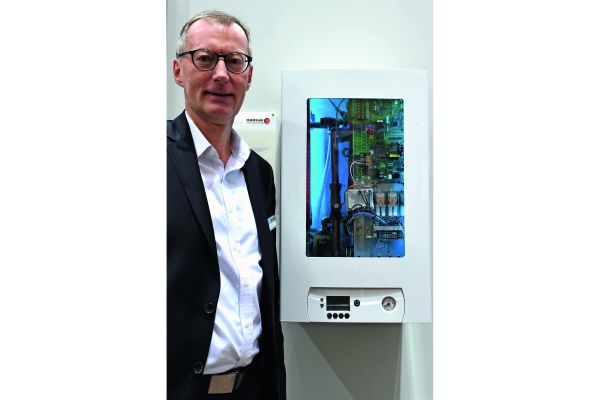 Der Geschäftsführer von Brötje mit der Luft/Wasser-Wärmepumpe SensoTherm BLW Split auf der ISH 2017.