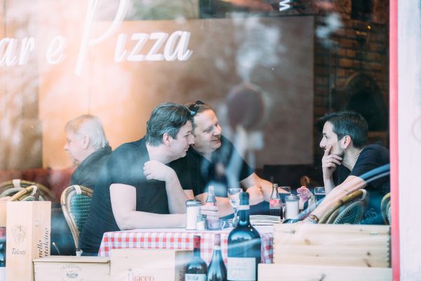 Andreas Lutzenberger, Helmut Schäffer und Christian Chymyn sitzen in einer Pizzeria.
