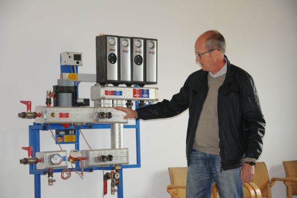 Der Vorstand der Energiegenossenschaft WeilerWärme eG Klaus Gall zeigt, wie die Übergabestationen der Nahwärmeversorgung funktionieren.