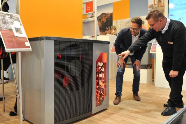 Jörg Schickedanz von Nibe Systemtechnik informiert einen Besucher über die Luft/Wasser-Wärmepumpen der Serie F2120.
