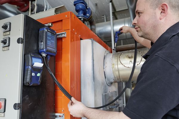Kundendienstmonteur Christian Michel von der Profi-Wärme-Service GmbH misst die Abgas-Emissionen an einem Brenner. 