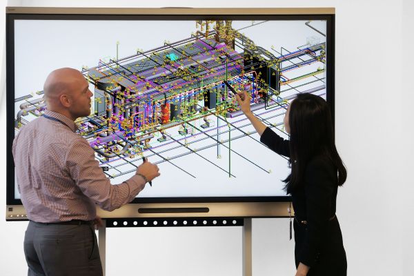 Zwei Planer besprechen ein BIM-Modell auf einem Bildschirm.
