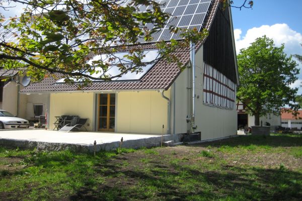 Ein Bauernhaus mit Photovoltaik-Anlage von außen.