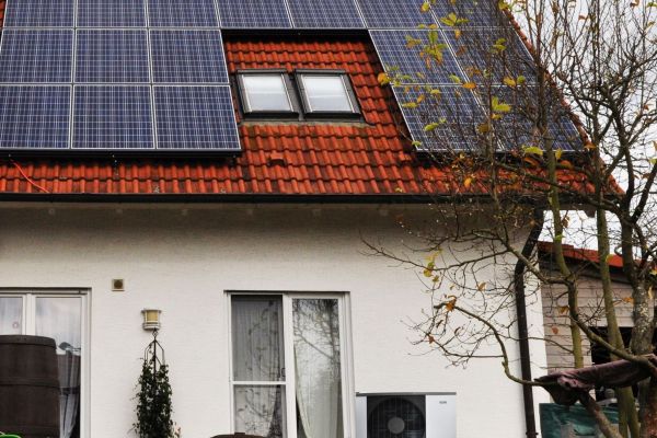 Ein Haus mit einer Photovoltaik-Anlage auf dem Dach.