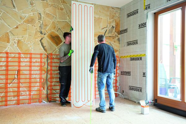 Zwei Handwerker beim Einbau von Wand-Modulen für eine Trockenbau-Wandheizung/Kühlung.