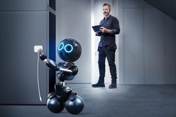 Ein Mann und ein Roboter stehen in einem Zimmer.