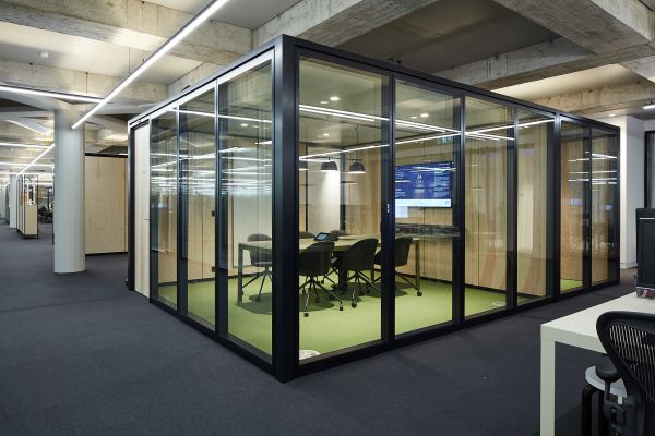 Ein Raum-in-Raum-System in einer offenen Bürofläche.