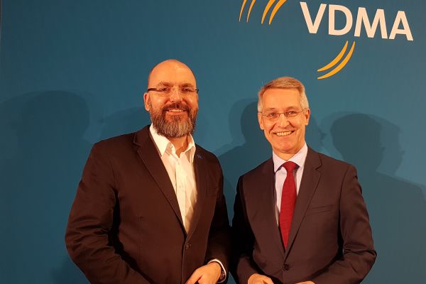 Zwei Männer stehen vor einer blauen Wand mit den weißen Buchstaben VDMA.